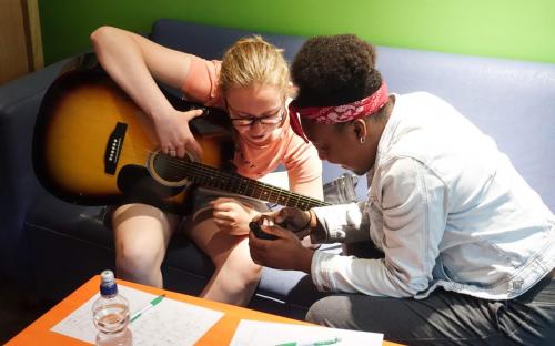Kaylagh and Naomi are practicing their love for music while they look at the picture Naomi took.